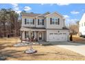 Lovely two-story home with gray siding, a covered porch, and a two-car garage at 106 Capanne Ct, Clayton, NC 27527