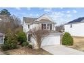 Charming home featuring a two-car garage with stone accents and classic architectural details at 108 Wagon Tie Ln, Garner, NC 27529
