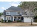 Charming two-story home featuring a well-manicured lawn and a classic covered front porch with rocking chairs at 1233 Dunn Creek Xing, Wake Forest, NC 27587