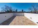 Spacious rooftop deck featuring wood-look tiling with city views beyond the surrounding trees at 226 Woodsborough Pl, Raleigh, NC 27601