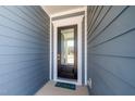 Close-up of a modern, black front door with a glass panel, and a welcoming 'hello' mat at 276 Bevis Marks Dr, Fuquay Varina, NC 27526