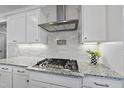 Close up on the kitchen with a gas cooktop, white cabinets, and granite countertops at 2907 Jakes View Pt, Fuquay Varina, NC 27526