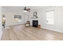Spacious living room with fireplace, wood-look floors, and ample natural light from multiple windows at 308 Arbor Crest Rd, Holly Springs, NC 27540