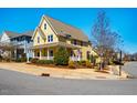 Picturesque yellow two-story home with a covered porch on a landscaped corner lot at 314 Tobacco Farm Way, Chapel Hill, NC 27516