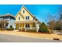 Two-story yellow home featuring a welcoming covered porch and mature trees in the yard at 314 Tobacco Farm Way, Chapel Hill, NC 27516
