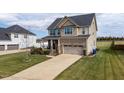 A shot of a brick and vinyl two-story house with a two car garage and a concrete driveway at 319 Brinkley Cir, Mebane, NC 27302