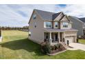 An exterior view of a two-story home with a cozy front porch and a well-maintained lawn at 319 Brinkley Cir, Mebane, NC 27302
