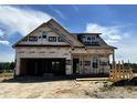 New construction home featuring a two-story design, attached garage, and builder's wrap visible on the exterior walls at 394 Springtooth Dr, Zebulon, NC 27597