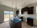 Bright kitchen with dark cabinets, stainless appliances, an island, and sliding doors to the backyard at 394 Springtooth Dr, Zebulon, NC 27597