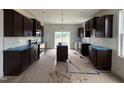 Bright kitchen with dark wood cabinets, stainless steel appliances, and a center island at 394 Springtooth Dr, Zebulon, NC 27597