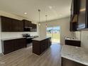 Modern kitchen features dark cabinetry, granite countertops, subway tile backsplash, and stainless appliances at 394 Springtooth Dr, Zebulon, NC 27597