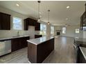 Open concept living and kitchen area with fireplace, stainless appliances and granite countertops at 394 Springtooth Dr, Zebulon, NC 27597