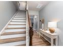 Bright entryway featuring stairs, wood floors, decorative table, and access to other rooms at 410 Pintail Ct, Durham, NC 27704