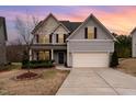 Charming two-story home with vinyl siding, mature landscaping, and a two-car garage at sunset at 410 Pintail Ct, Durham, NC 27704