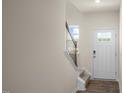 Bright entryway featuring hardwood floors, a staircase with dark railings, and a white front door at 416 Belgian Red Way, Wake Forest, NC 27587