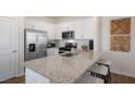 Stylish kitchen featuring white cabinets, stainless appliances, and a granite countertop island with seating at 416 Belgian Red Way, Wake Forest, NC 27587