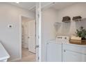 Bright laundry room featuring a white washer and dryer, wire shelving, and a view into the bathroom at 422 Belgian Red Way, Wake Forest, NC 27587