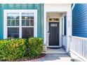 Welcoming front entrance with a black door, decorative window, and manicured landscaping at 424 Hopwood Way, Apex, NC 27523