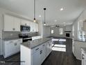 Open kitchen featuring an island with granite countertops and stainless steel appliances at 450 Springtooth Dr, Zebulon, NC 27597