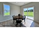 Cozy dining area with a round table, black chairs, and a view of the outdoor space at 472 Springtooth Dr, Zebulon, NC 27597