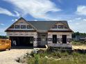 New construction home featuring an attached two-car garage and covered front porch at 472 Springtooth Dr, Zebulon, NC 27597