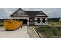 Front exterior of a new home under construction, with a garage, and lawn surrounded by trees at 472 Springtooth Dr, Zebulon, NC 27597