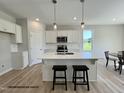 Bright kitchen featuring a large island, stainless steel appliances, and white cabinets at 472 Springtooth Dr, Zebulon, NC 27597