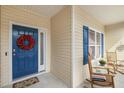 Inviting front porch with blue door and colorful wreath, offering a welcoming entrance at 55 Oak Leaf Dr, Lillington, NC 27546