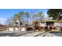 A tan home featuring a three car garage, second floor balcony and a brick foundation at 6301 King Lawrence Rd, Raleigh, NC 27607