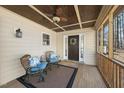 Inviting front porch with seating, ceiling fan, and view of the entry door at 6301 King Lawrence Rd, Raleigh, NC 27607