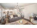 Open-concept living space with hardwood floors, neutral decor, and a view of the kitchen and staircase at 710 Legacy Falls S S Dr, Chapel Hill, NC 27517