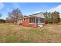 Side view of a brick home with a screened-in porch and a well-kept yard at 7415 Old Oxford Rd, Bahama, NC 27503