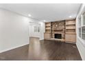 Spacious living room boasting hardwood floors, built-in shelving, and a striking stone fireplace at 7725 Longstreet Dr, Raleigh, NC 27615