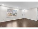 Bright and airy living room featuring hardwood floors, a large window, and fresh, neutral paint at 7725 Longstreet Dr, Raleigh, NC 27615