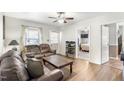 Comfortable living room with hardwood floors, a ceiling fan, and view into the bedroom at 805 S 11Th St, Lillington, NC 27546