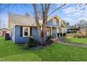 Cozy home with a side yard, covered porch, blue siding, and yellow trim accents at 805 S 11Th St, Lillington, NC 27546