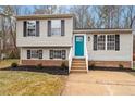 Charming split-level home with a manicured front yard, blue door, and black shutters at 8341 Wynewood Ct, Raleigh, NC 27616