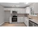 Bright kitchen features stainless appliances, granite countertops, and modern white cabinetry at 8341 Wynewood Ct, Raleigh, NC 27616