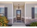 Elegant front entrance features a black door with glass panes and stone accents at 84 Nonabell Ln, Four Oaks, NC 27524