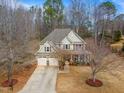 Inviting two-story home with a three-car garage, classic siding, a covered porch, and established trees at 94 Fawn Hill Ct, Garner, NC 27529