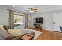 Stylish living room featuring hardwood floors, ample natural light, modern furnishings, and a ceiling fan at 1005 Helms Pl, Raleigh, NC 27610