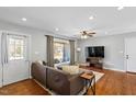 Bright living room boasts hardwood floors, a large window, neutral decor, and comfortable seating at 1005 Helms Pl, Raleigh, NC 27610