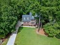 An aerial view showcases a brick home nestled among lush, mature trees and landscaping at 102 Legault Dr, Cary, NC 27513