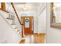 Bright foyer with hardwood floors, featuring a decorative glass-paneled front door and staircase at 102 Legault Dr, Cary, NC 27513