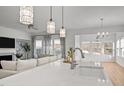 Bright, open-concept kitchen featuring island seating, pendant lighting, and seamless flow to the living area at 1026 Janiskee Rd, Durham, NC 27703