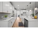 Spacious kitchen with white cabinets, stainless steel appliances, wooden floors, and large island at 1026 Janiskee Rd, Durham, NC 27703