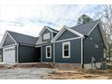 An exterior view showing a new dark green home with a black roof and a two-car garage at 109 Averly Ct, Stem, NC 27581