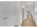 Bright hallway featuring wood floors, white trim, and a glimpse into the living spaces at 119 Canary Ct, Raleigh, NC 27610
