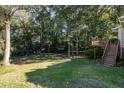 Lush backyard featuring a wooden deck and mature trees, providing a private outdoor space at 1224 Manchester Dr, Raleigh, NC 27609