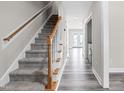 Inviting hallway with hardwood floors leading to a carpeted staircase at 1707 Stroll Cir, Fuquay Varina, NC 27526